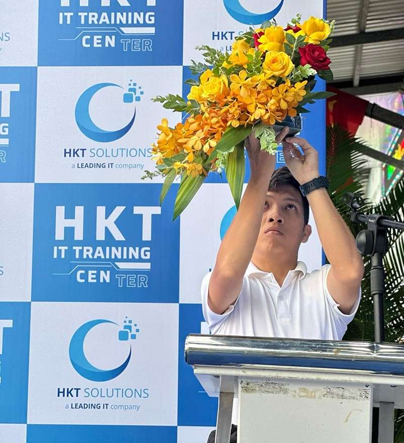 Nhân viên nam trang trí hoa vàng cho bục sự kiện