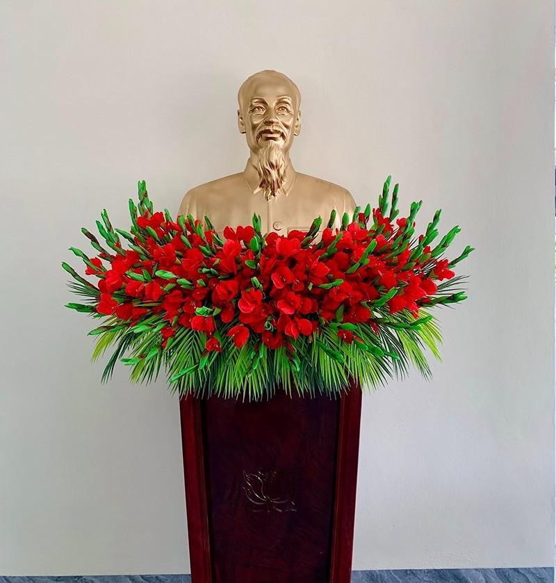Bục phát biểu có hình bác hồ trang trí hoa đỏ