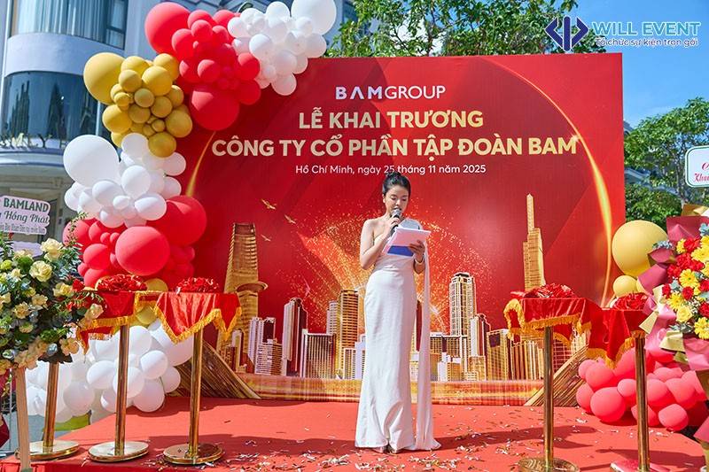 MC đang dẫn chương trình trước backdrop khai trương Bamland