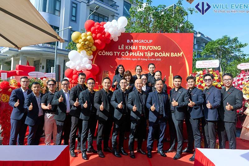 Các thành viên công ty bất động sản Bamland măc vest đen đứng chụp trước background