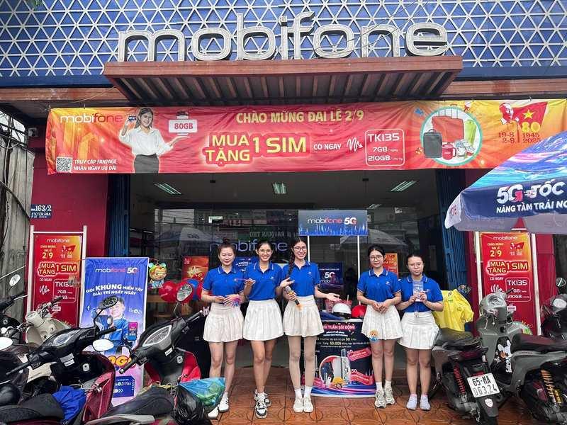 ALT: Nhóm PG sự kiện mặc đồng phục xanh trắng cho thuê PG sự kiện theo giờ chuyên nghiệp HCM tại cửa hàng Mobifone.