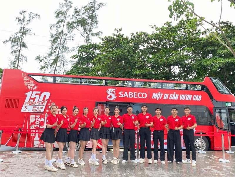 Nhóm PG sự kiện đứng trước xe buýt đỏ, dịch vụ cho thuê PG sự kiện theo giờ chuyên nghiệp tại HCM.