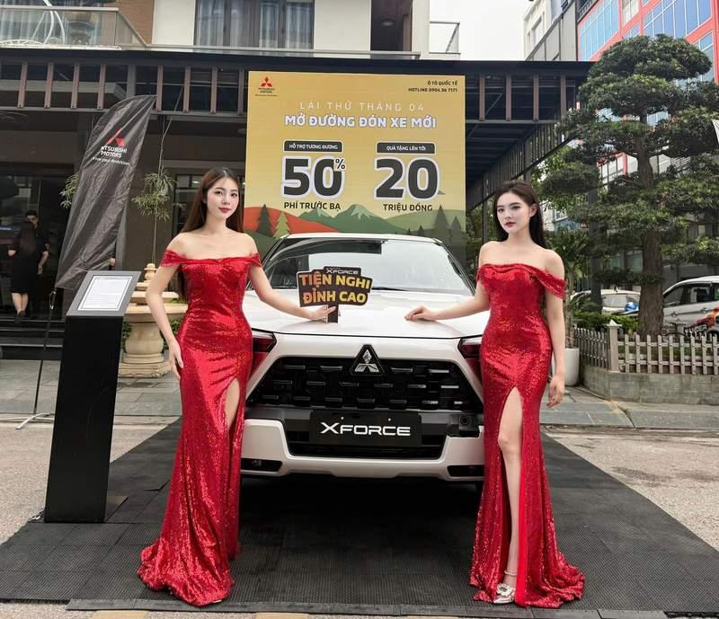 Cho thuê PG sự kiện theo giờ chuyên nghiệp HCM bên cạnh xe Mitsubishi Xforce trắng.