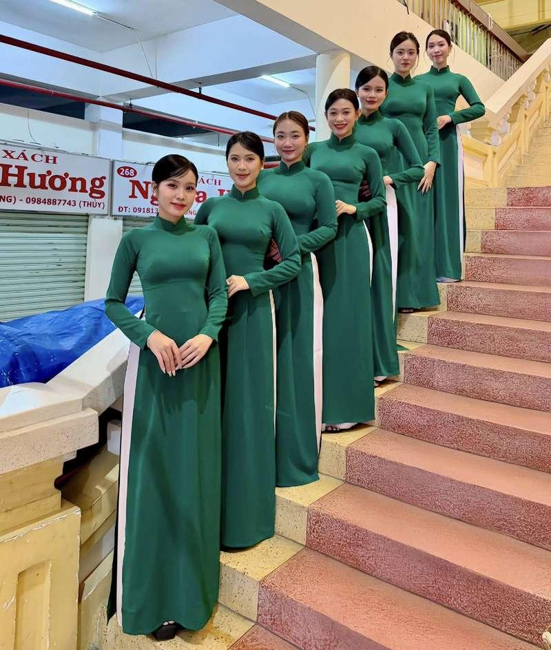 Cho thuê PG sự kiện theo giờ chuyên nghiệp HCM với đồng phục áo dài xanh đứng trên cầu thang.