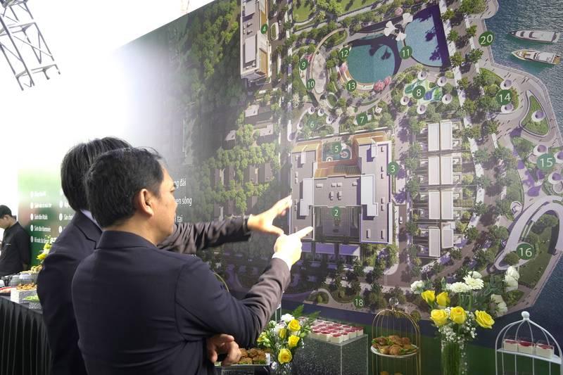 ALT: Người tham dự lễ khởi công xây dựng trọn gói chuyên nghiệp đang trao đổi kế hoạch trên bản vẽ dự án.