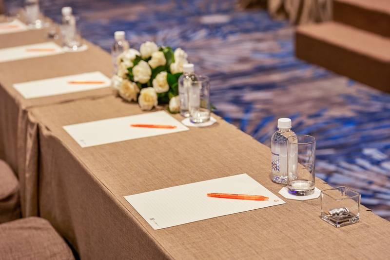 Bàn họp chuẩn bị giấy, bút và nước phục vụ tổ chức đại hội cổ đông chuyên nghiệp trọn gói HCM.