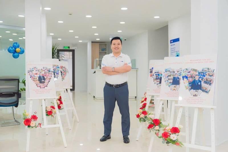 Nam giới đứng giữa các giá đỡ khung tranh sự kiện được trang trí hoa, dịch vụ cho thuê giá đỡ khung tranh sự kiện giá rẻ HCM.