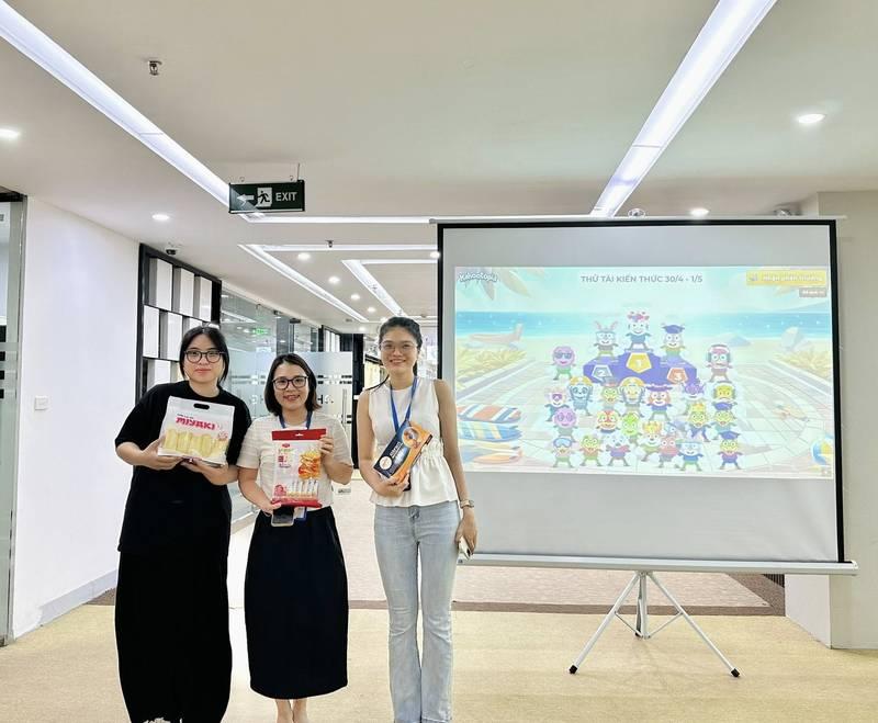 Ba người đang tham gia sự kiện với màn hình trình chiếu trò chơi, thể hiện dịch vụ cho thuê tài khoản Kahoot sự kiện 1000 người bản quyền.