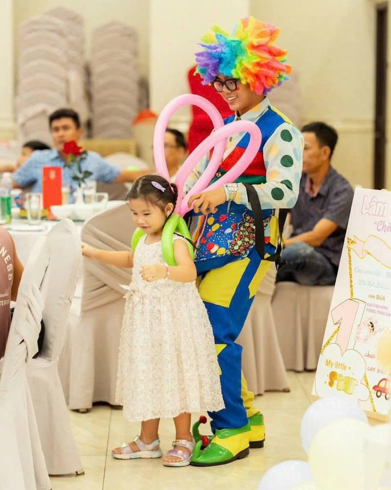 Cho thuê chú hề hoạt náo xiếc ảo thuật chuyên nghiệp HCM đang tặng bóng nghệ thuật cho bé gái trong tiệc.