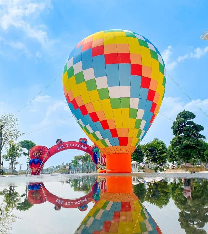 Thuê khinh khí cầu sự kiện chuyên nghiệp tại TP.HCM với bóng bay màu sắc nổi bật phản chiếu trên mặt nước.