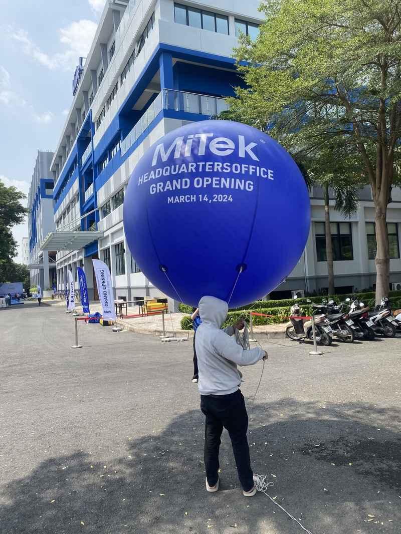 Người đang cầm khinh khí cầu xanh trong sự kiện ngoài trời, cho thuê khinh khí cầu sự kiện chuyên nghiệp tại TP.HCM.