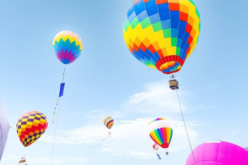 Cho thuê khinh khí cầu sự kiện chuyên nghiệp tại TP.HCM với nhiều khinh khí cầu màu sắc rực rỡ bay trên bầu trời xanh.